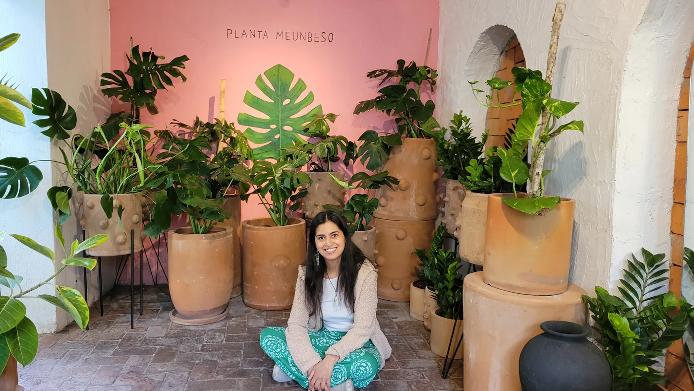 Alicia seated among plants