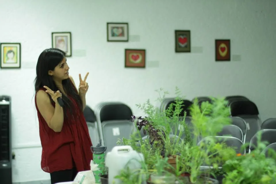 Alicia teaching beside a table of plants