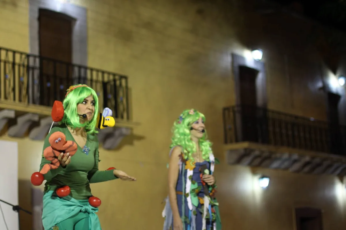 The Plantañol actors performing in green costumes with headsets